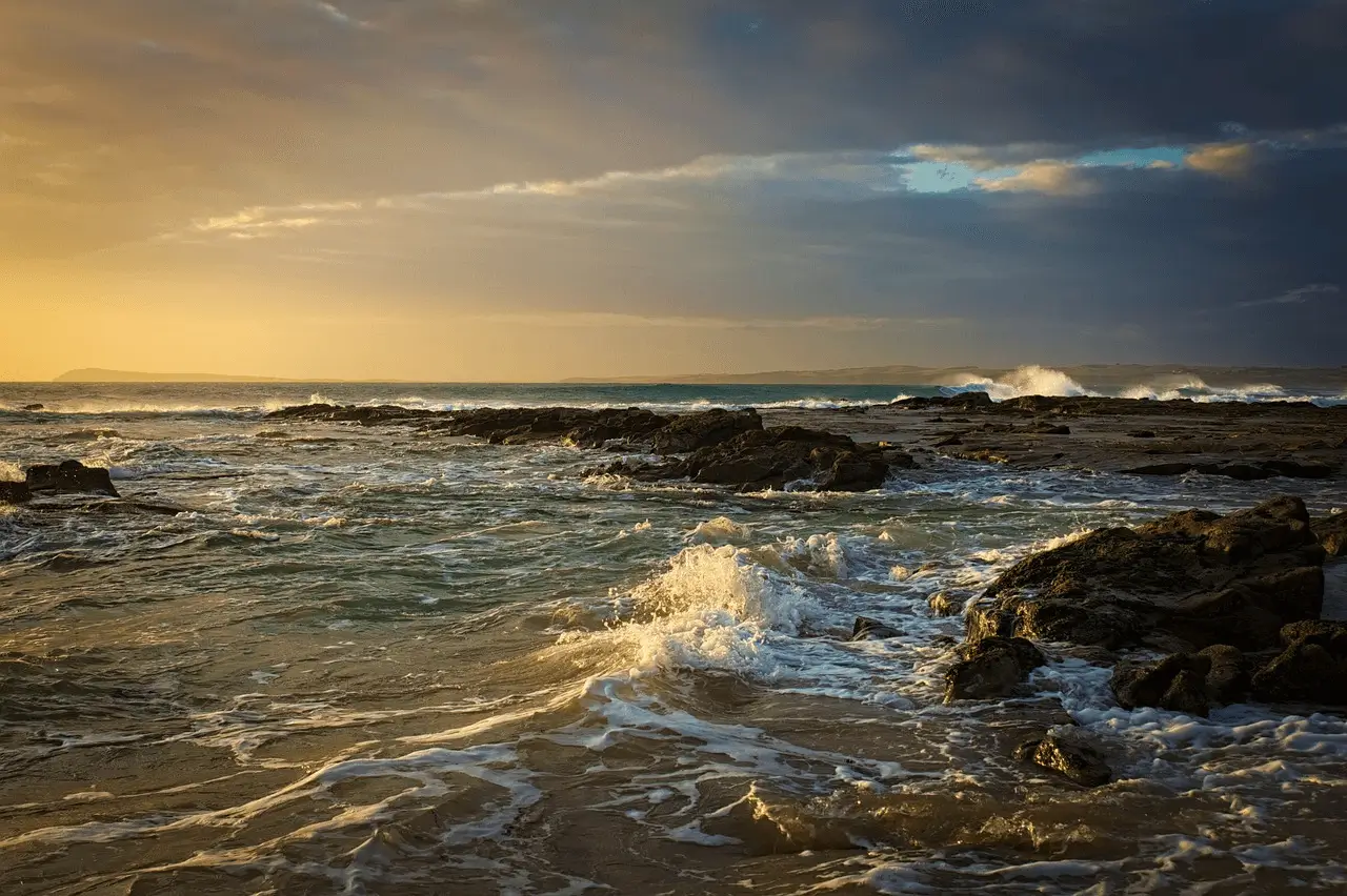 crashing waves on rocky coast in the golden hour