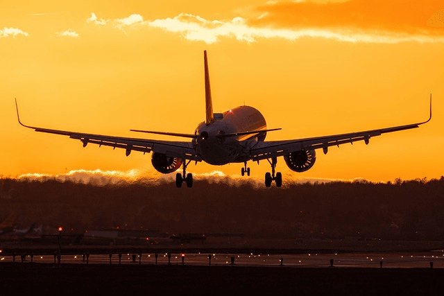 airplane taking off in sunset