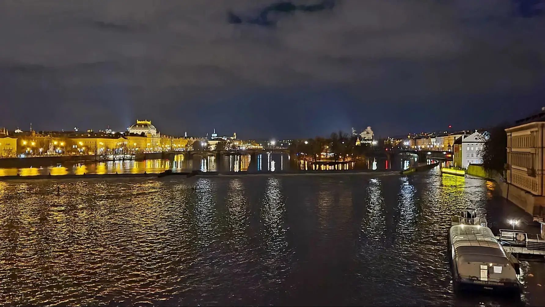 view on river with skyline of Prague at night time