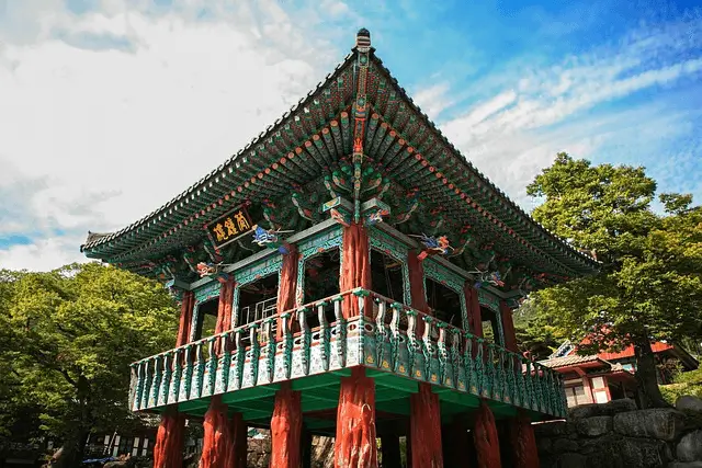 Japanese temple with trees in the background and blue sky